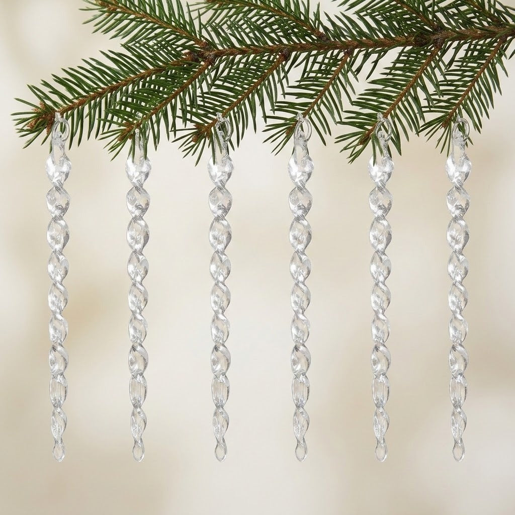 Six clear acrylic twisted icicle Christmas ornaments hang from a green evergreen branch against a softly blurred cream background.