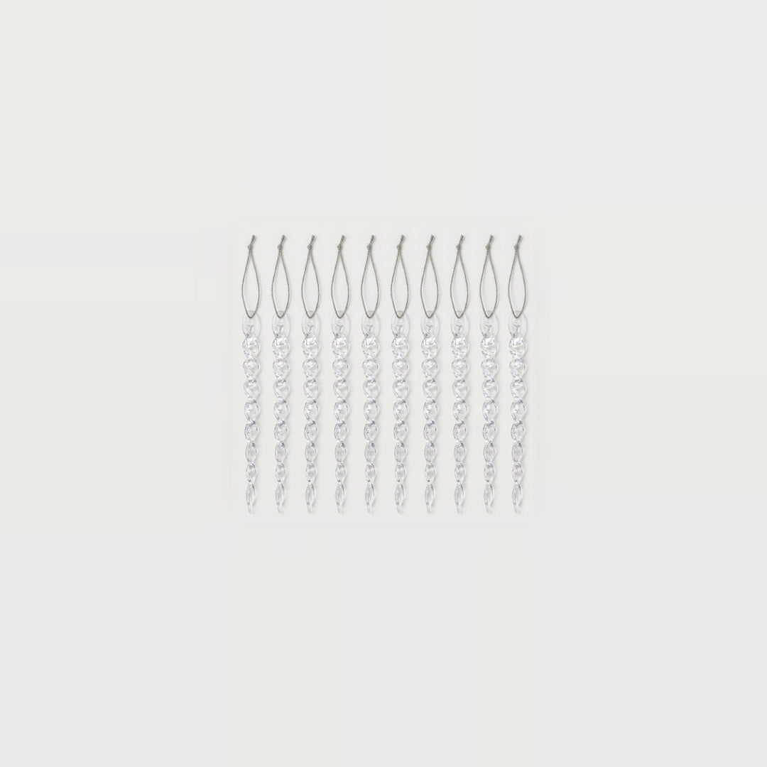 Ten clear twisted icicle ornaments with silver hanging loops form a compact row centered against a white background.