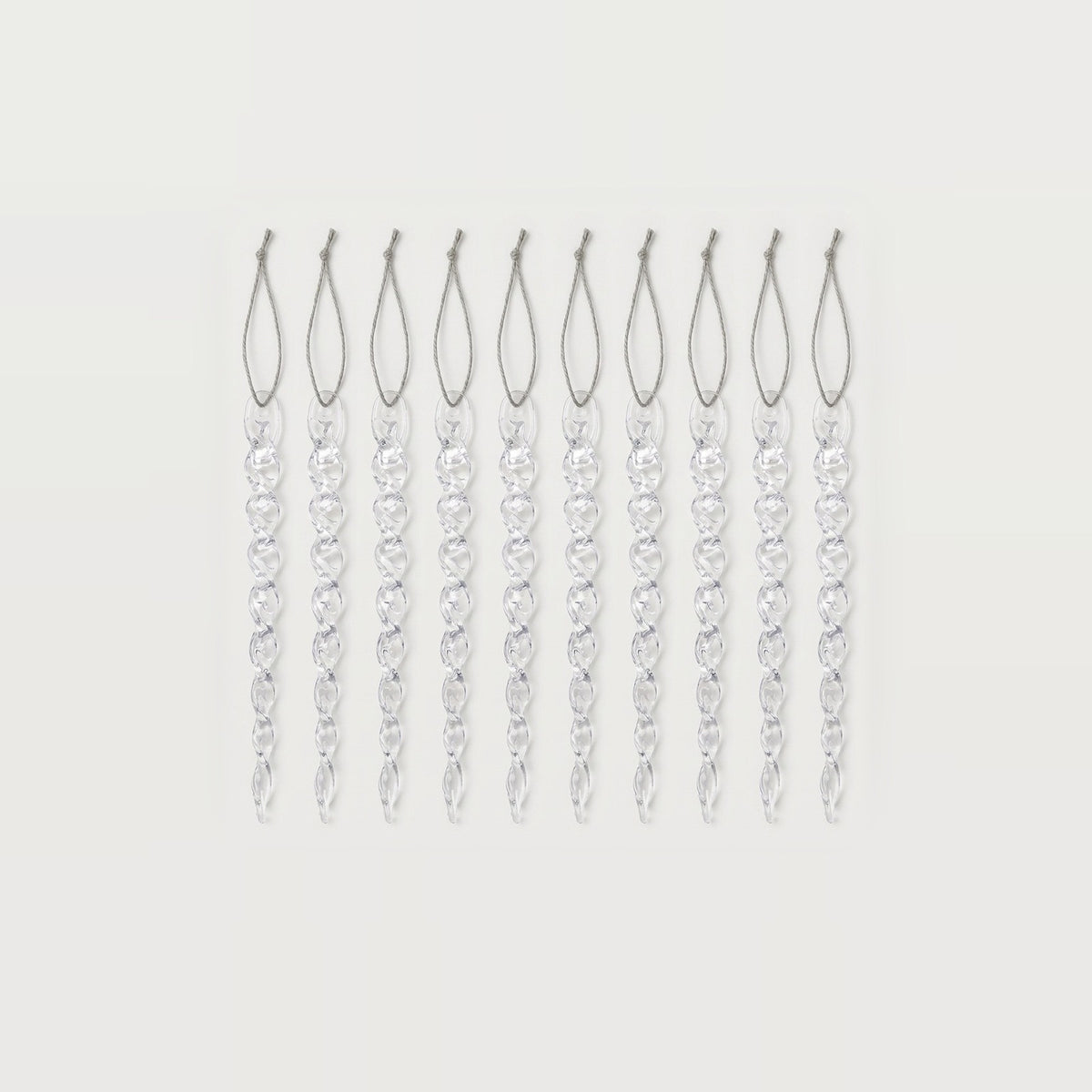 Ten clear icicle ornaments with twisted tapered bodies and silver hanging loops are arranged in a row on white.