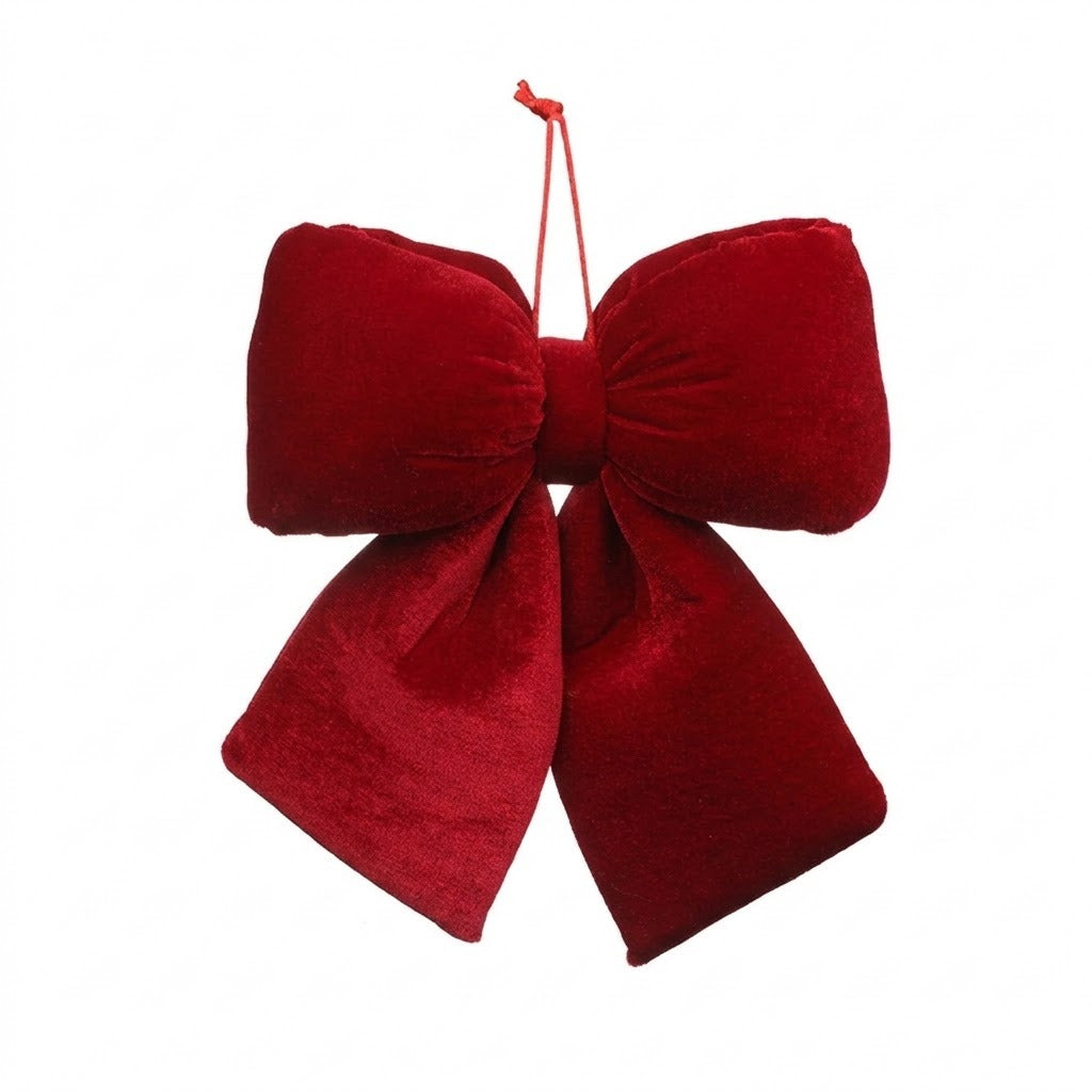 A red velvet Christmas bow with gathered loops, two wide tails, and a red hanging cord appears against a white background.