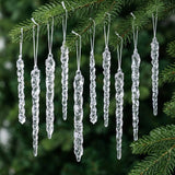 Clear tapered icicle ornaments hang at staggered heights from green tree branches against a dark green background.