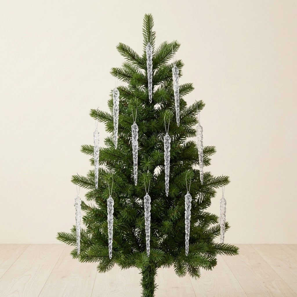 Clear icicle ornaments hang from a small green Christmas tree against a cream wall above a pale wooden floor.
