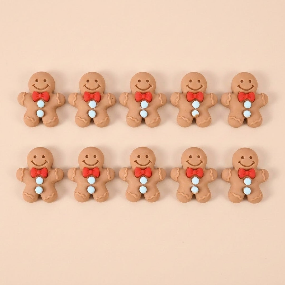 Ten brown resin gingerbread craft embellishments with red bows and pale blue buttons sit in two rows against peach.
