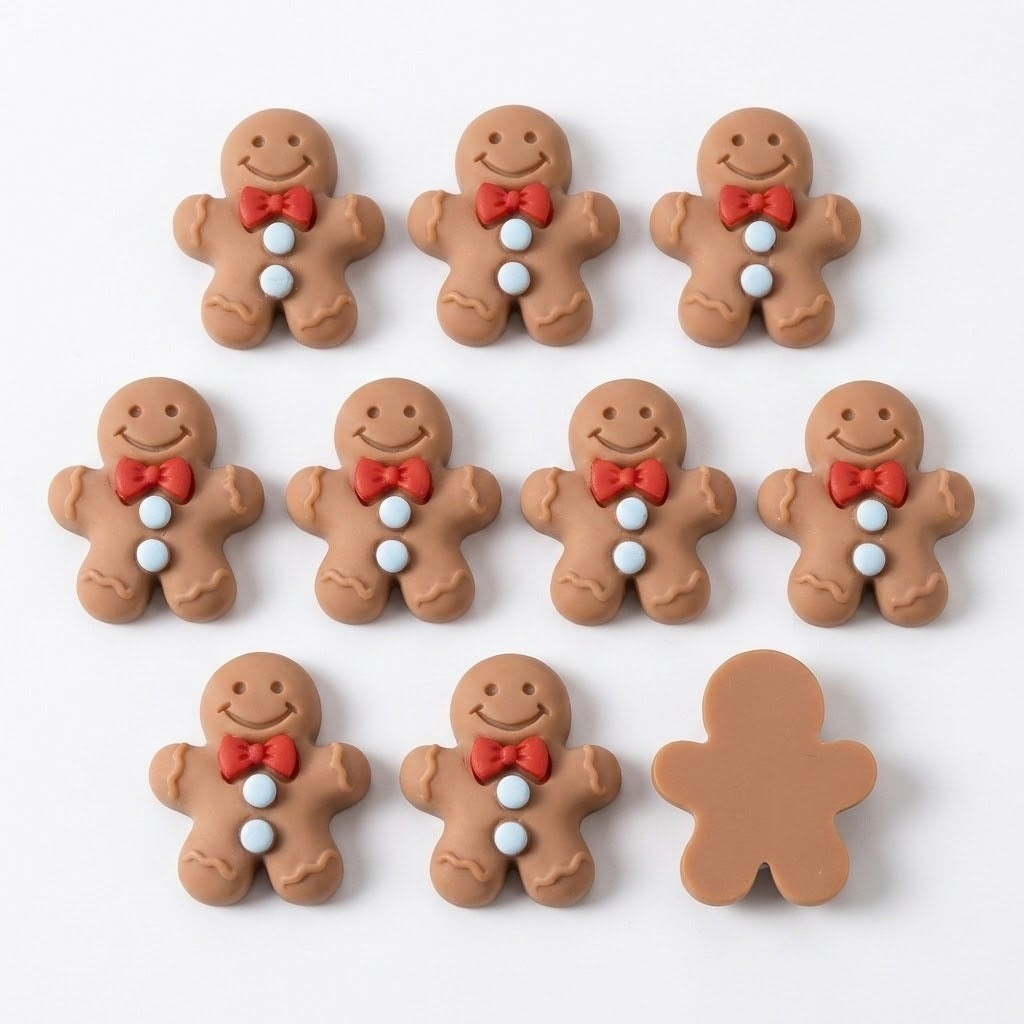Ten brown resin gingerbread craft embellishments lie on white, with nine decorated fronts and one plain flat back visible.