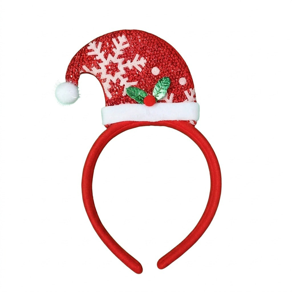 A red Christmas headband with a glittery Santa hat, white snowflakes, fluffy trim, and green holly appears against a white background.