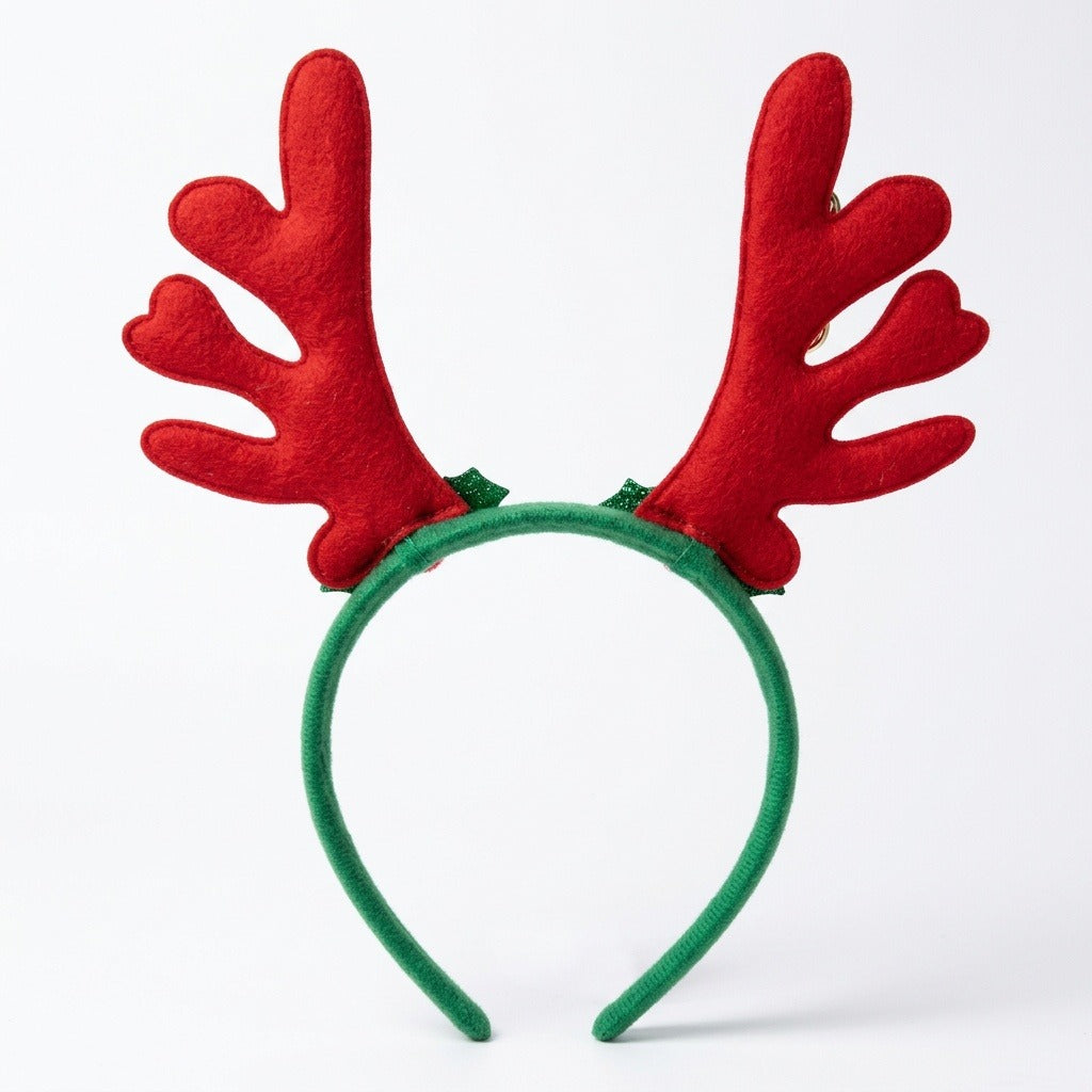 Green fabric Christmas headband with tall red felt-like antlers and small green glitter accents stands upright against a white background.