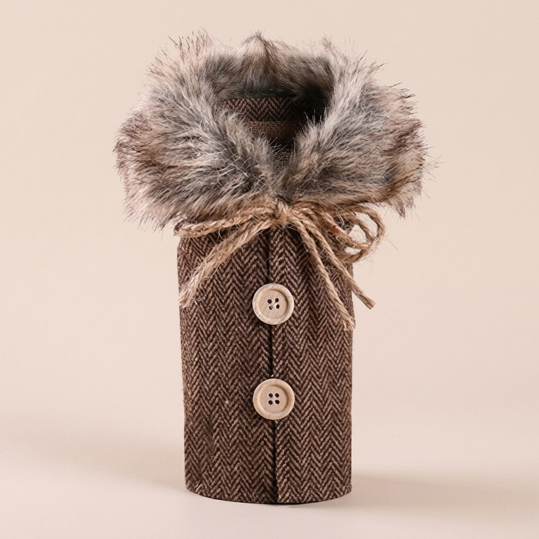 Brown herringbone wine bottle cover has a fluffy gray collar, twine bow and two beige buttons against a pale beige background.