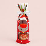Red printed reindeer wine bottle cover tied with a silver bow shows a Warm Wishes sign against a pale pink background.