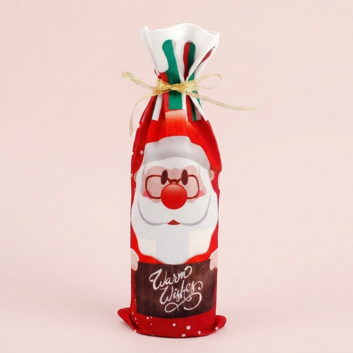 Red cloth wine bottle cover features a Santa print, Warm Wishes lettering and gold ribbon against a pale pink background.