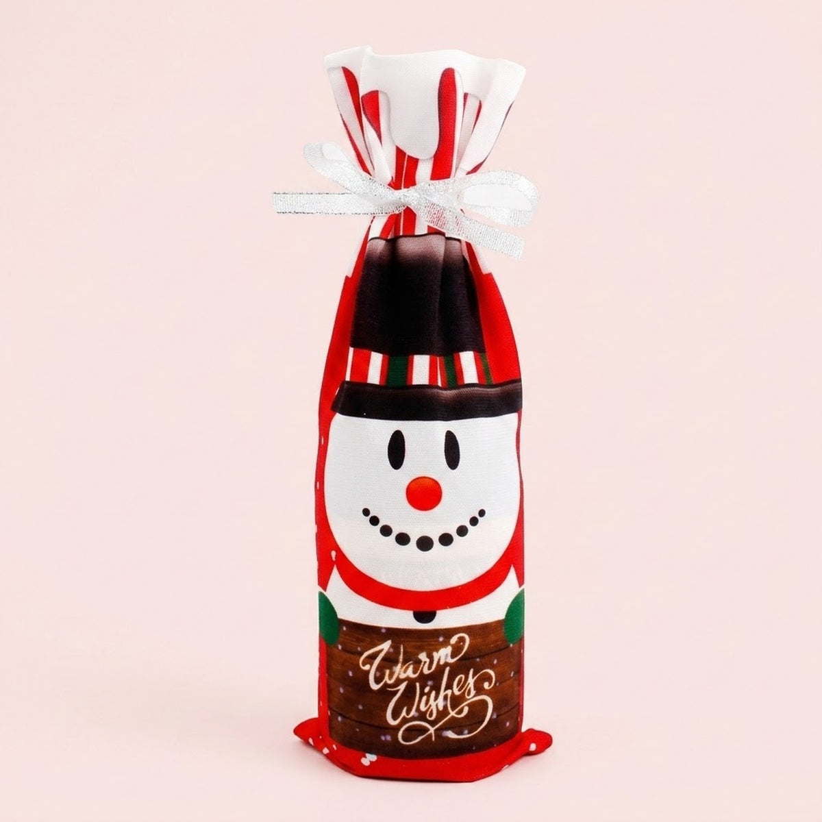 Red cloth wine bottle cover features a snowman print, Warm Wishes lettering and white ribbon against a pale pink background.