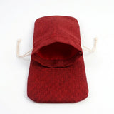 Red textured fabric wine bottle cover lies flat on white with its opening spread wide and cream drawstrings extended.