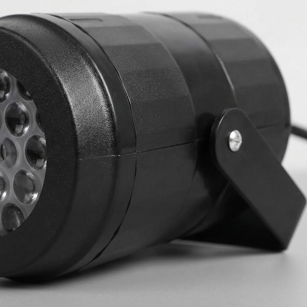 Black Christmas light projector appears close up against white, showing textured casing, partial circular lenses, and a stand with a silver screw.