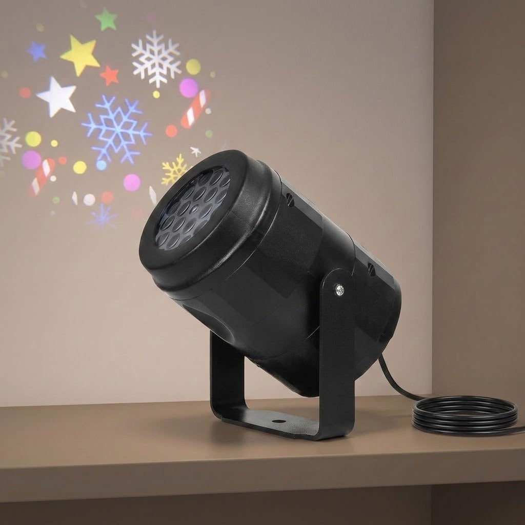 Black Christmas light projector sits tilted on a beige shelf beside coiled cable, projecting colorful stars, snowflakes, and candy canes onto the wall.
