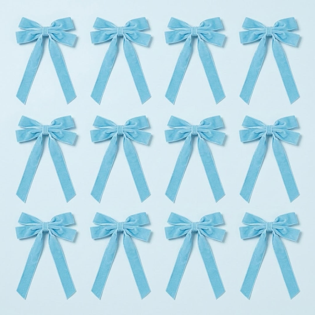 Twelve light blue velvet Christmas bows with long angled tails are arranged in three rows of four on a pale blue background.