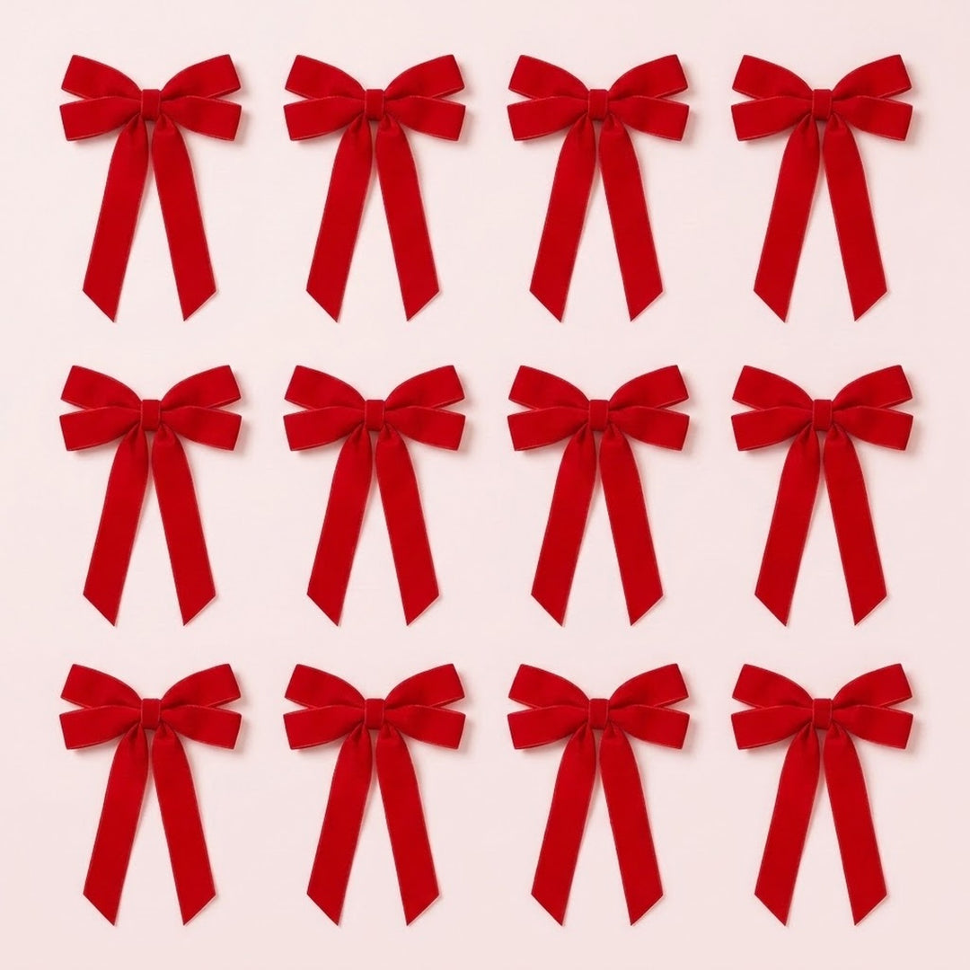 Twelve red velvet Christmas bows with long angled tails are arranged in three rows of four on a pale pink background.