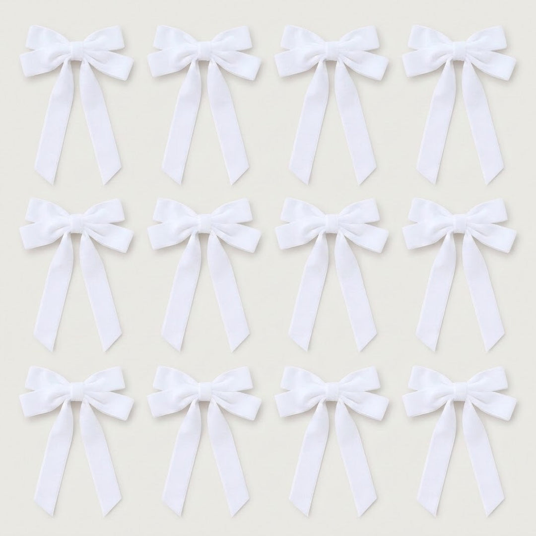 Twelve white velvet Christmas bows with long angled tails are arranged in three rows of four on a light gray background.