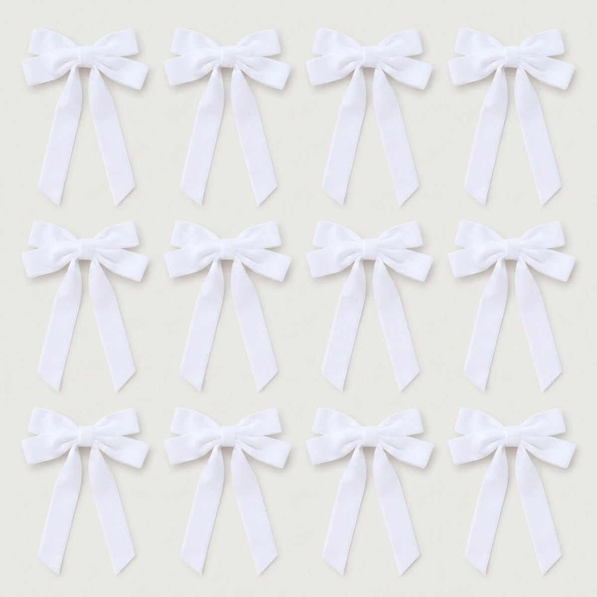 Twelve white velvet Christmas bows with long angled tails are arranged in three rows of four on a light gray background.
