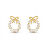 Two matching gold-tone bow stud earrings with white pearl-like beads and clear faceted stones stand side by side against white.