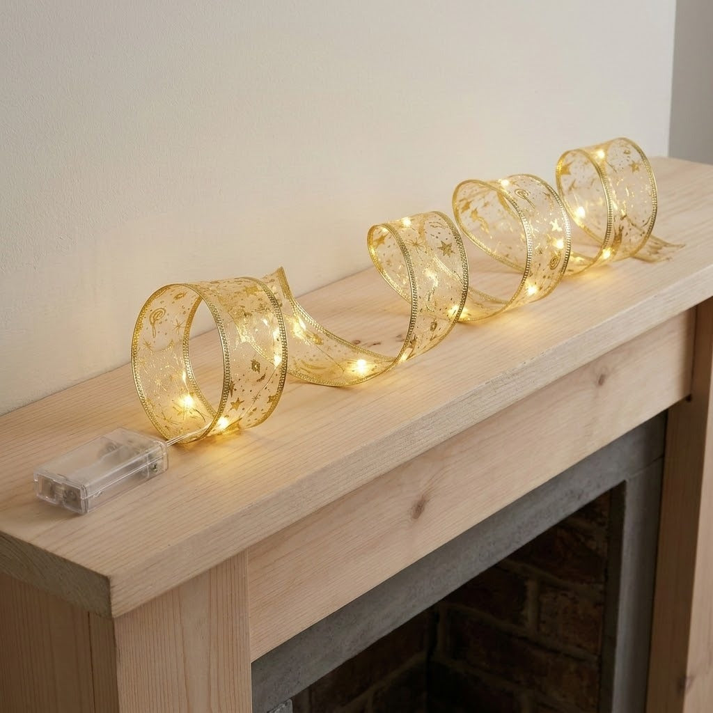 A glowing gold ribbon light string forms upright loops across a pale wooden fireplace mantel, with a clear battery box at one end.