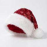 A festive Santa hat featuring a red sequined crown, a fluffy white faux fur trim, a red velvet inner lining, and a white pom-pom, shown on a clean white background.