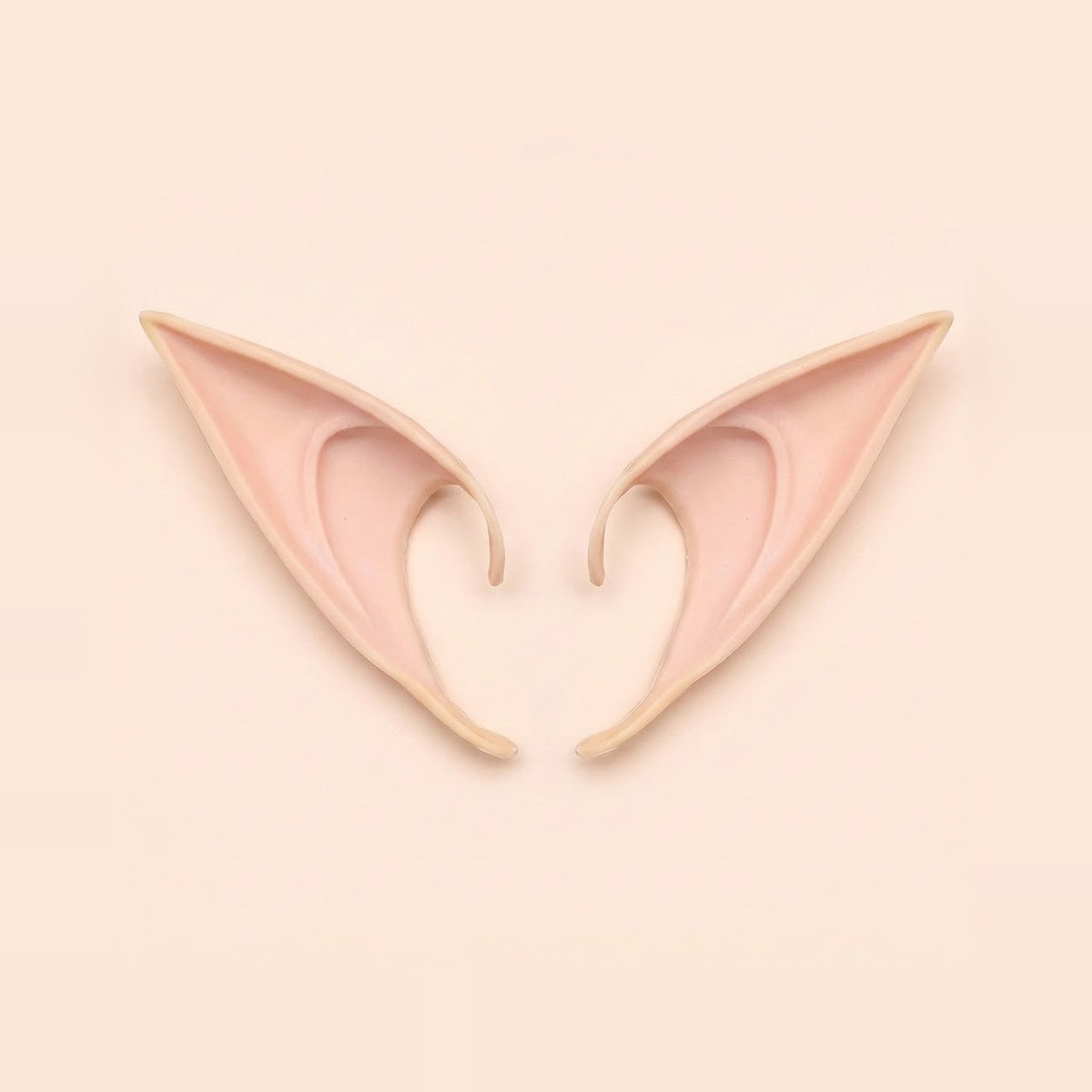 Light peach latex elf costume ears with curved hooks lying side by side on a pale peach background, 4.72 in (12 cm) pair.