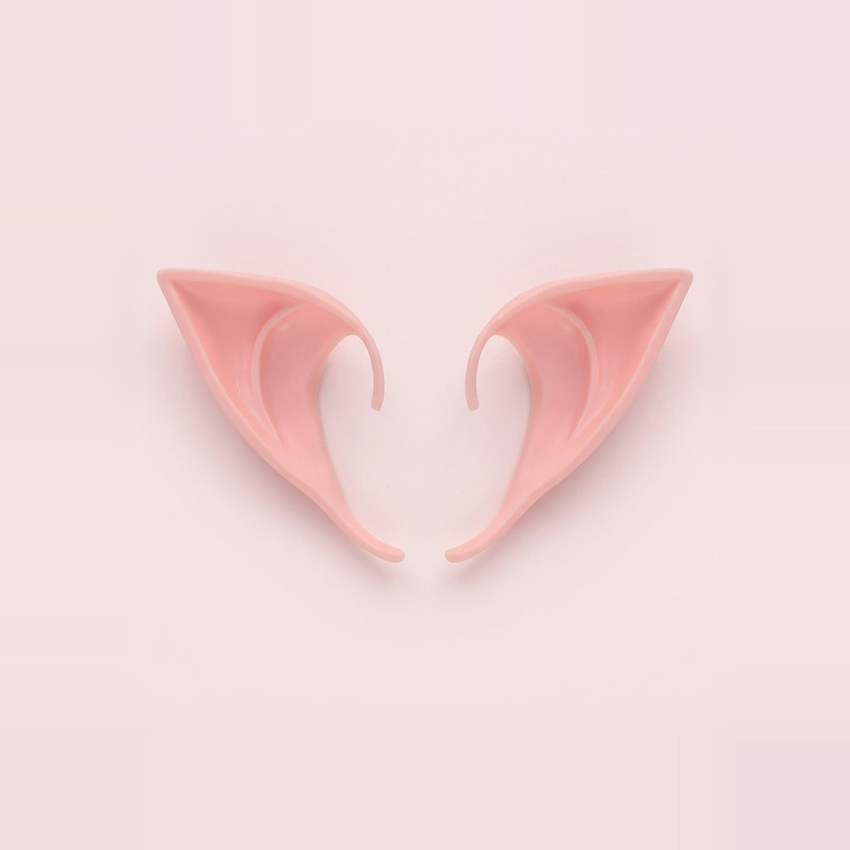 Pink latex elf costume ears with curved hooks lying side by side on a pale pink background, 3.94 in (10 cm) pair.