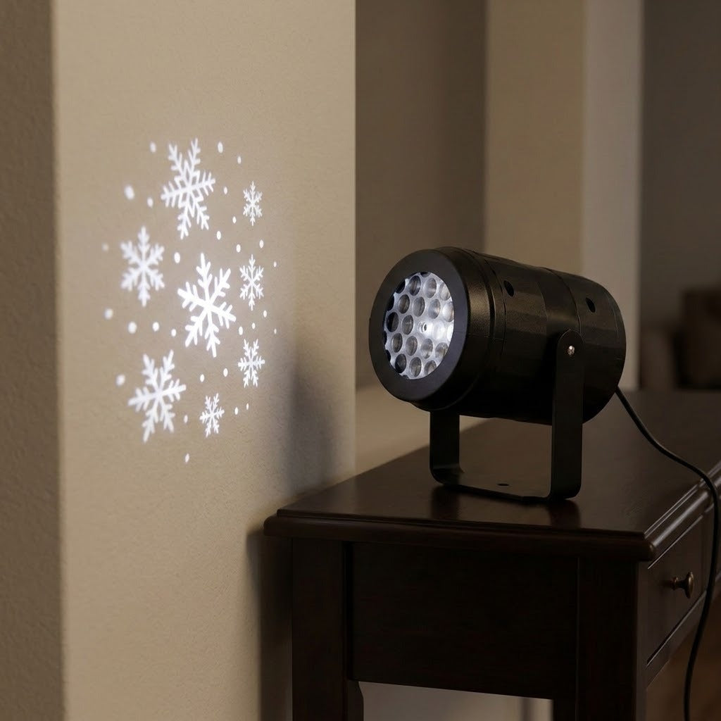 A black projector stands on a dark wooden console table, casting white snowflakes and dots onto a nearby cream wall.
