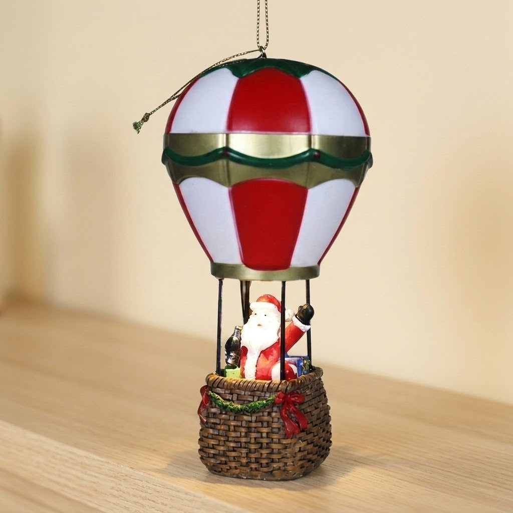 Red and white Santa hot air balloon Christmas decorative light hangs above a wooden shelf against a beige wall.