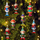 Eight colorful elf ornaments hang by gold strings among Christmas tree branches illuminated with warm lights.