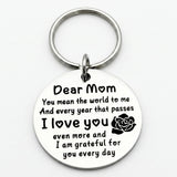 Silver circular keychain displays a black Dear Mom message and rose motif beneath a round split ring on a white background.