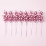 Eight pink glitter berry picks with long pink stems stand side by side on a pale pink background.