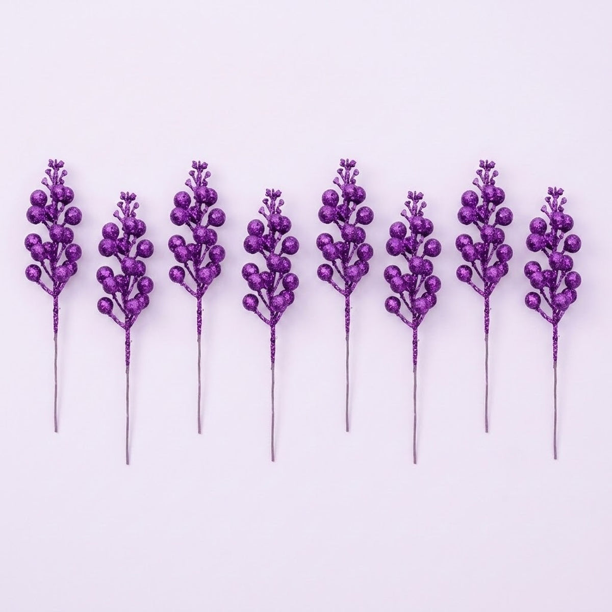 Eight purple glitter berry picks with exposed gray stems alternate heights in a row on a pale lavender background.