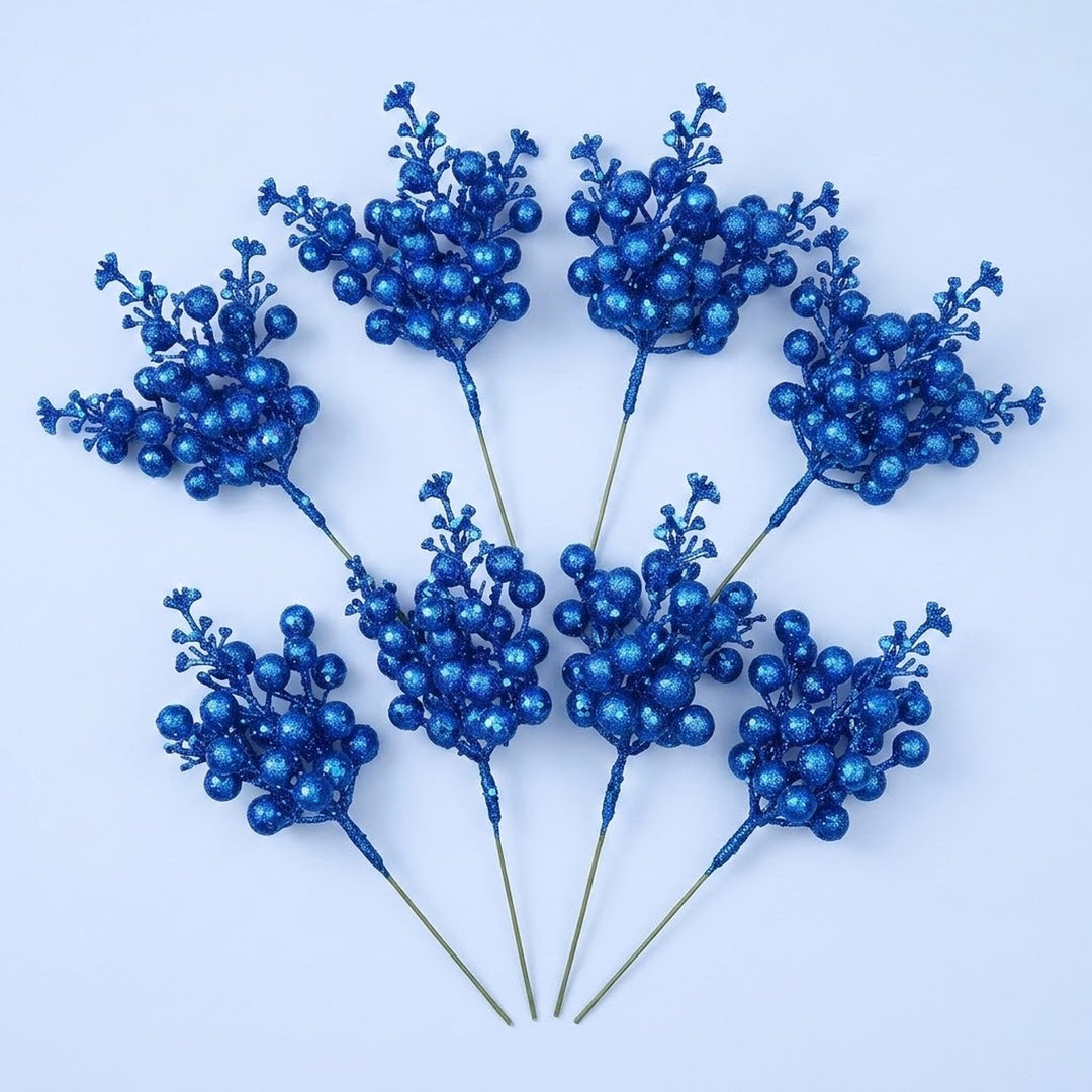 Eight royal blue glitter berry picks with slender green stems form two fans on a pale blue background.