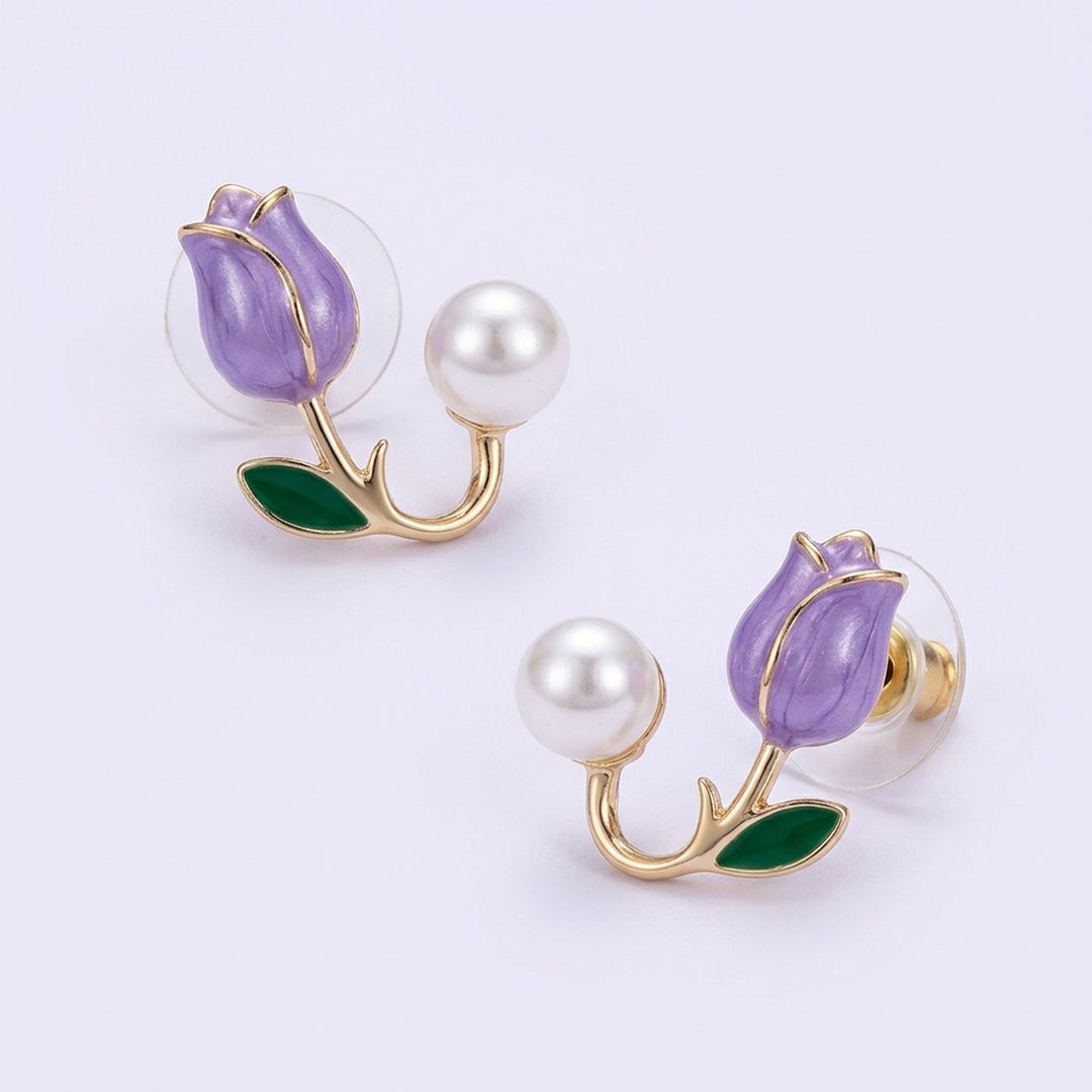 Lavender tulip stud earrings with gold-tone stems, green leaves, white pearl-like beads, and clear circular backs on a pale lavender background.