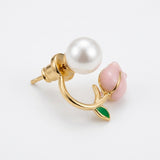 An angled tulip stud earring displays its gold-tone post and push-back, white pearl-like accent, pink bud, and green leaf on white.