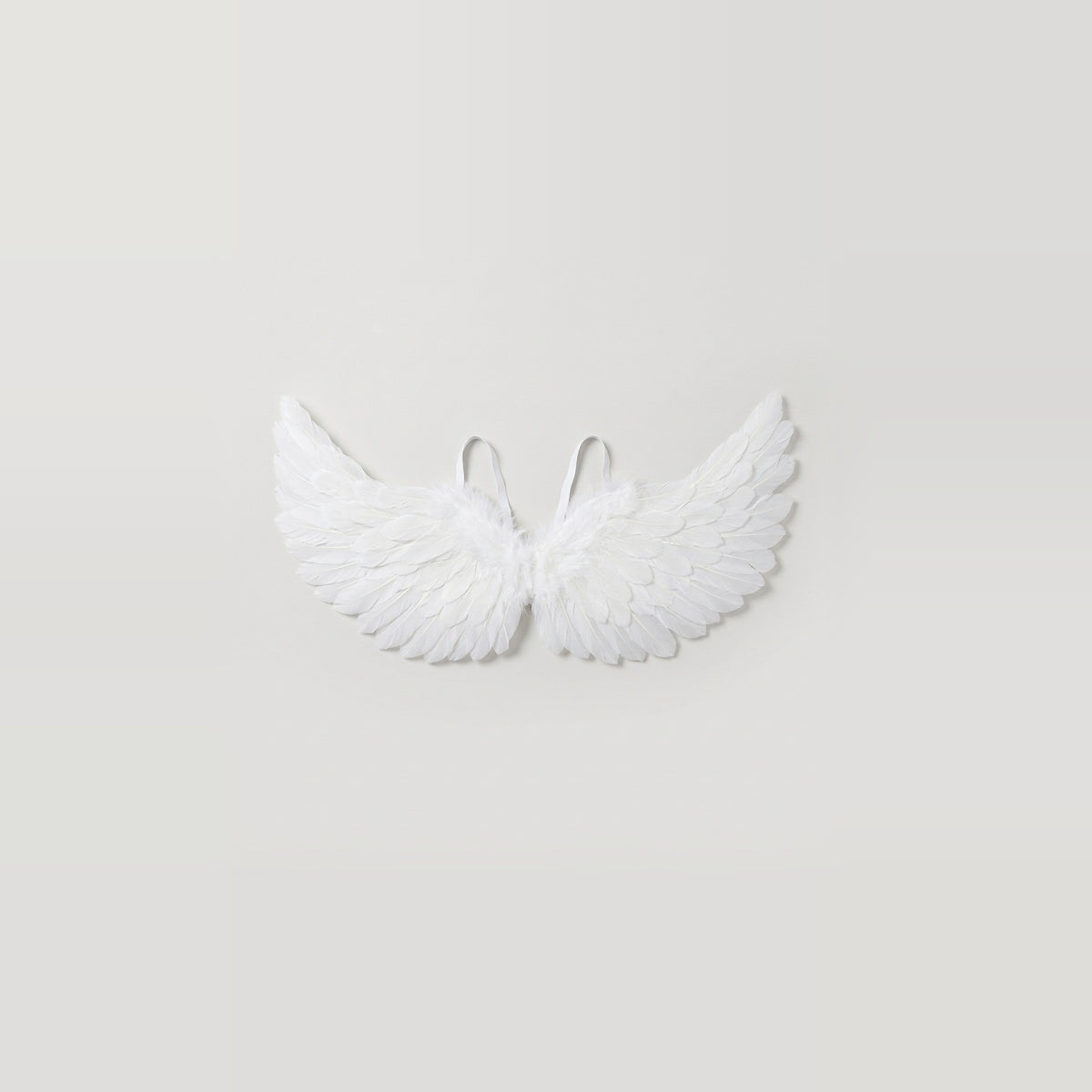 White feather costume wings have raised tips and two visible shoulder loops, centered against a light gray background.