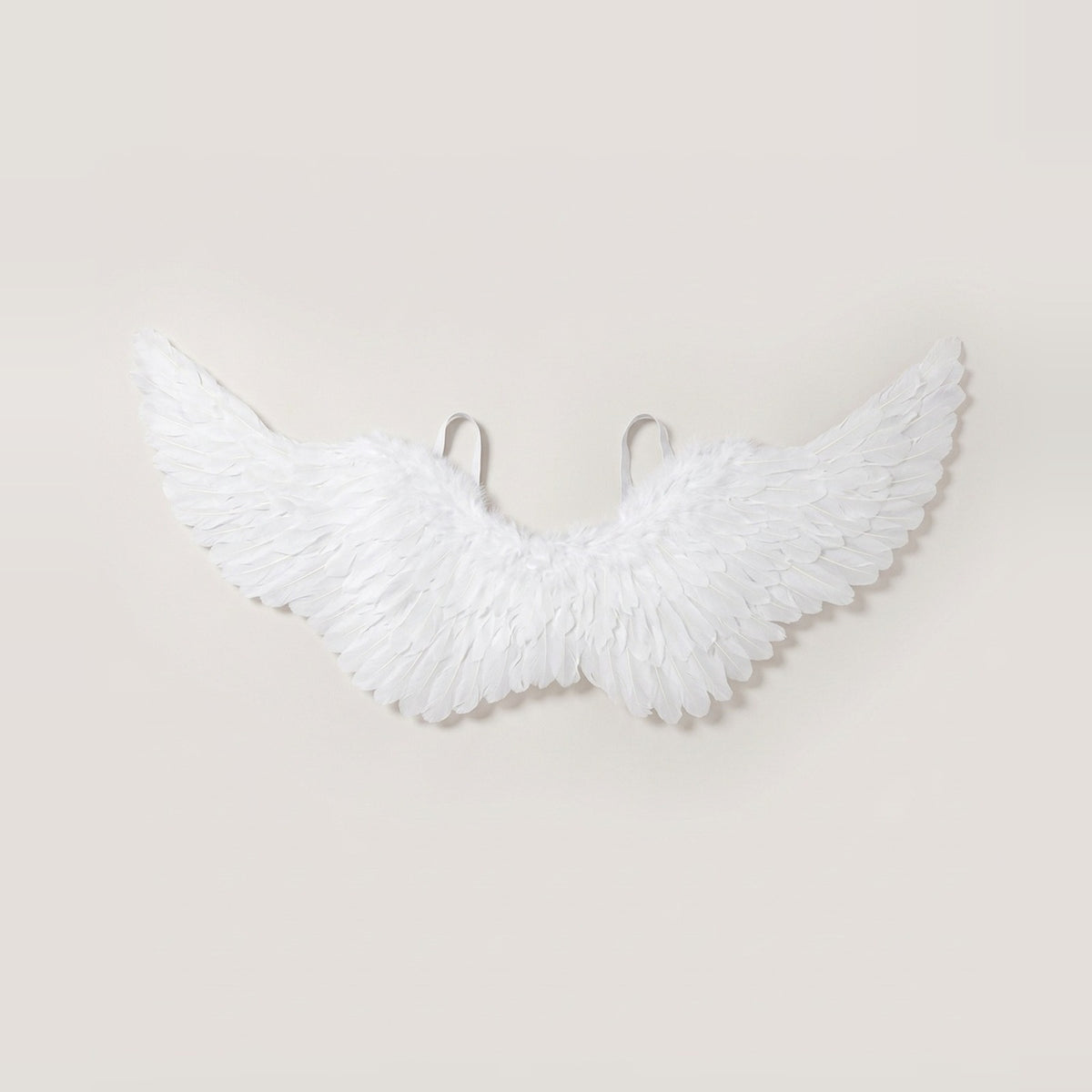 White feather angel wings costume with elastic shoulder straps laid flat against a light background, size 39.4 x 17.7 in (100 x 45 cm).