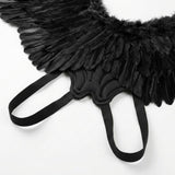 Close-up of black feather costume wings showing the fabric-covered centre and two elastic shoulder loops against a white background.