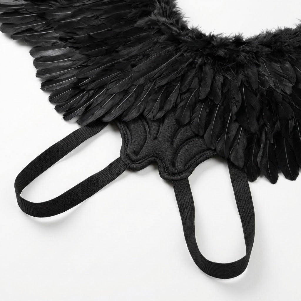 Close-up of black feather costume wings showing the fabric-covered centre and two elastic shoulder loops against a white background.