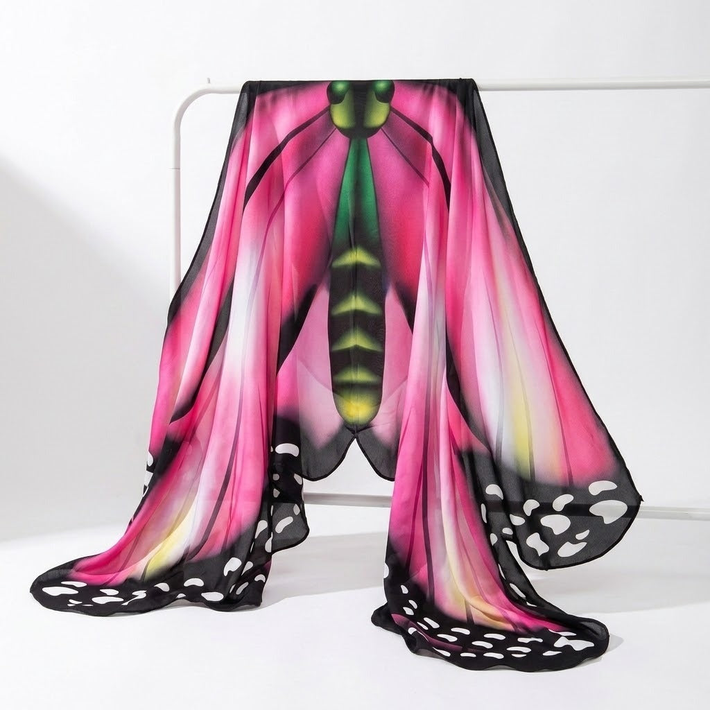 Pink butterfly wings costume cape with green and yellow body print draped over a white clothes rail against a white background.