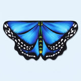 Bright blue butterfly wing cape with black spotted edges and a green body, laid flat on a pale blue background.