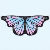 Pastel blue and pink butterfly wing cape with black veined wings and white spots, laid flat on a light blue background.