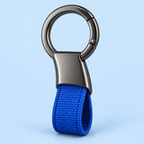 Blue Zinc Alloy Carabiner Keychain with a gunmetal circular ring on a soft blue studio background.