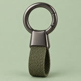 Green Zinc Alloy Carabiner Keychain with a gunmetal circular ring on a soft sage studio background.