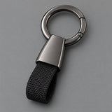 Black Zinc Alloy Carabiner Keychain with a gunmetal circular ring on a light charcoal studio background.