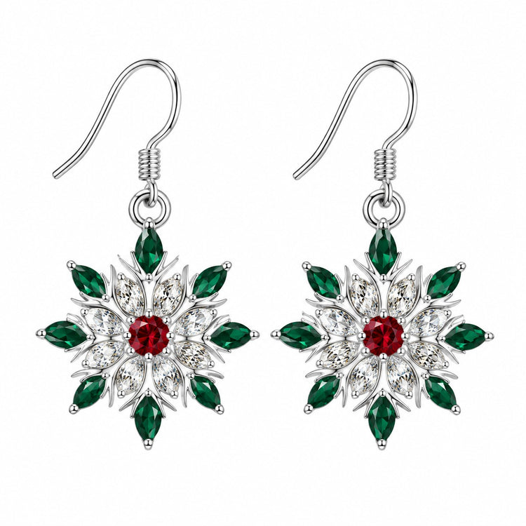 A matching pair of red and green accented snowflake stud earrings on a pure white background.