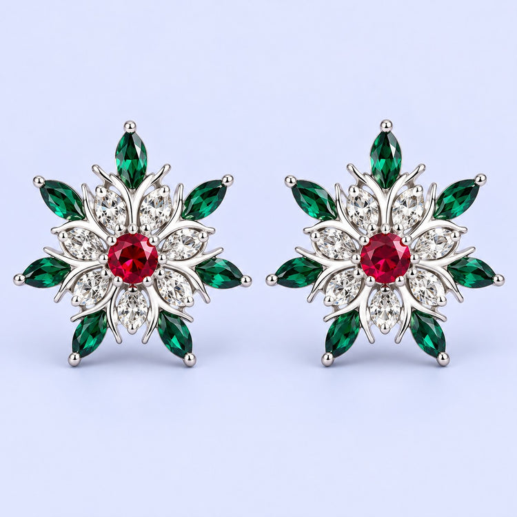 Silver snowflake stud earrings with red and green stones on a pale icy lavender backdrop.