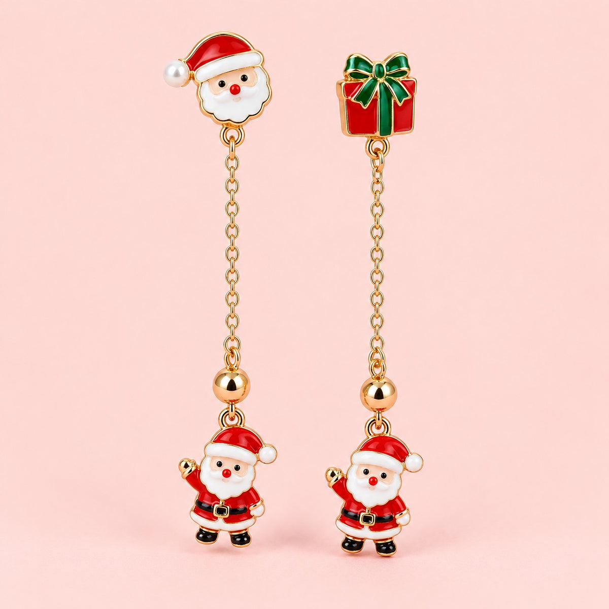 Long Santa and gift earrings with gold-tone chains on a soft blush background.