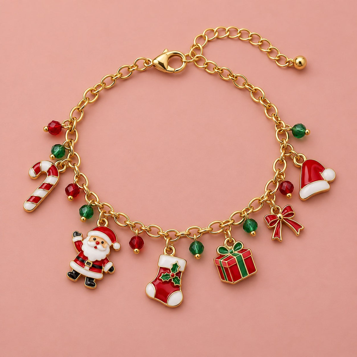 Gold Christmas charm bracelet with Santa, stocking, gift and candy cane charms on a soft blush studio backdrop.