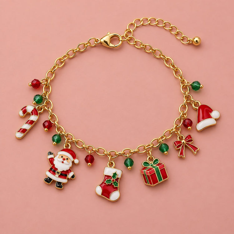 Gold Christmas charm bracelet with Santa, stocking, gift and candy cane charms on a soft blush studio backdrop.